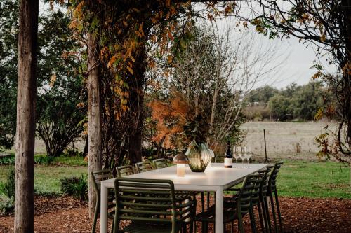 a white table with chairs sitting under a tree at The Cudgee at Mudgee in Mudgee