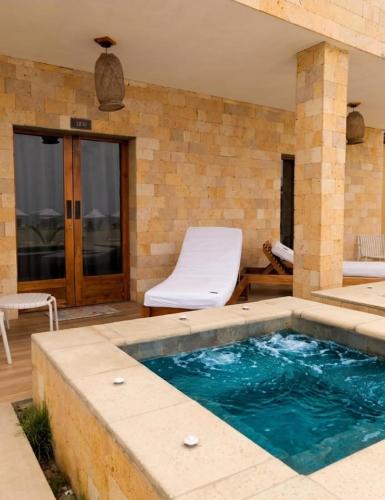 a small swimming pool in a patio with a chair at Posada Las Rosas Inn in Quizandal