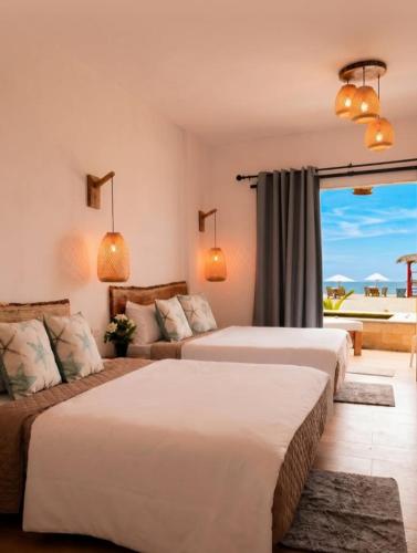 a hotel room with two beds and a couch at Posada Las Rosas Inn in Quizandal