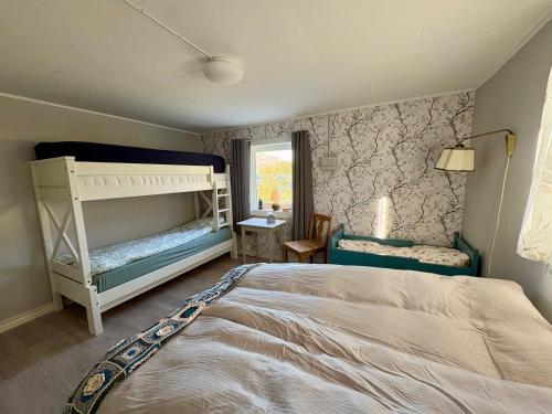 a bedroom with two bunk beds and a window at Fornes Bed & Breakfast in Fornes
