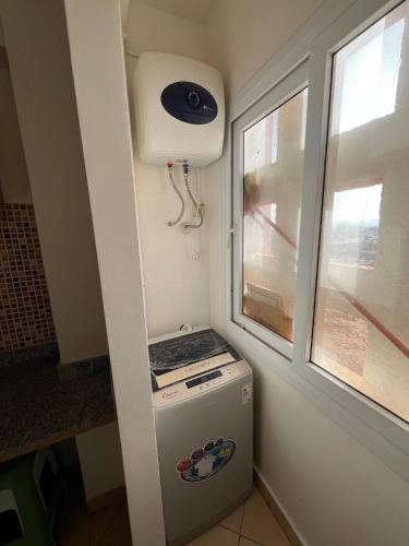 a small refrigerator in a kitchen next to a window at Cozy Appartement for vacation in Agadir