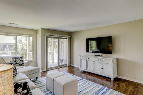 a living room with a couch and a flat screen tv at Courtside 56 in Hilton Head Island