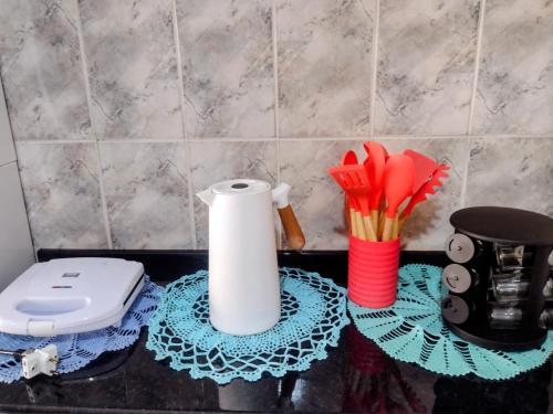 a bathroom counter with a toilet paper roll and utensils at Casa na área central com 3 quartos in São Pedro