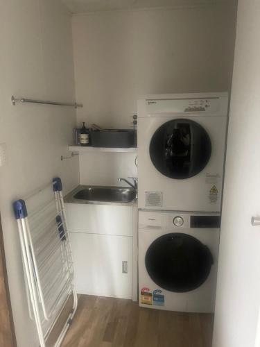 a small kitchen with a washing machine and a sink at Cardrona mountain cottage in Cardrona
