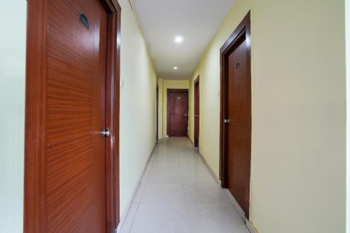a hallway with two wooden doors and a tile floor at Hotel O Pariwar Inn in Hyderabad