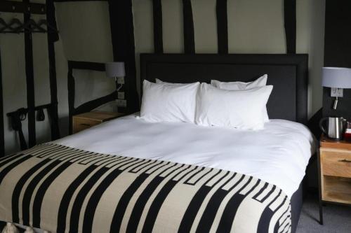 a large bed with white sheets and pillows at The Windmill in Maidstone
