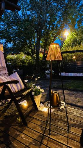 a lamp sitting on a deck next to a chair at Bollnäs Lugn och Ro in Bollnäs