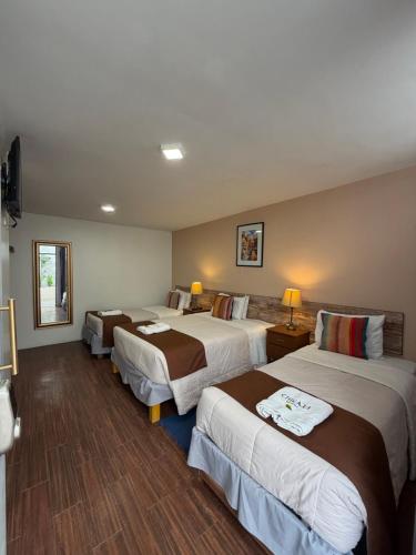 a hotel room with three beds and a television at Chikan Hoteles in Arequipa