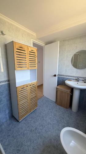 a bathroom with a sink and a toilet and a mirror at La Casa Azul en Ortigueira in Santa Marta de Ortigueira