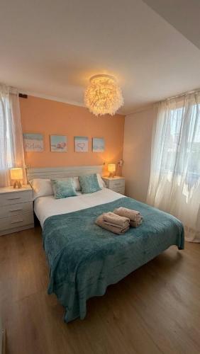 a bedroom with a large bed with towels on it at La Casa Azul en Ortigueira in Santa Marta de Ortigueira