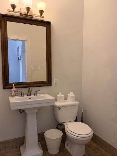 a bathroom with a toilet and a sink and a mirror at The Vurpillat in Hermosa Beach