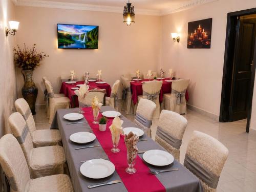 a dining room with a long table and chairs at TCHASSHOUSE Motel in Yaoundé