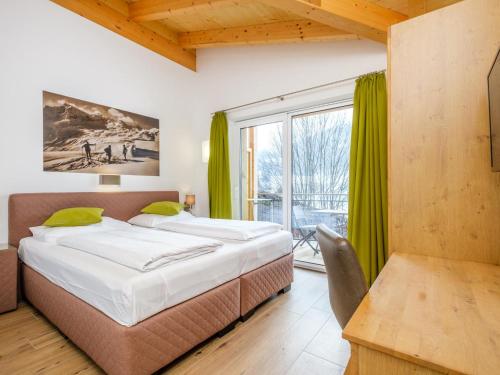a bedroom with a bed and a large window at Hochkönigblick I in Werfenweng