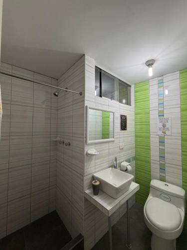 a bathroom with a white toilet and a sink at Chikan Hoteles in Arequipa