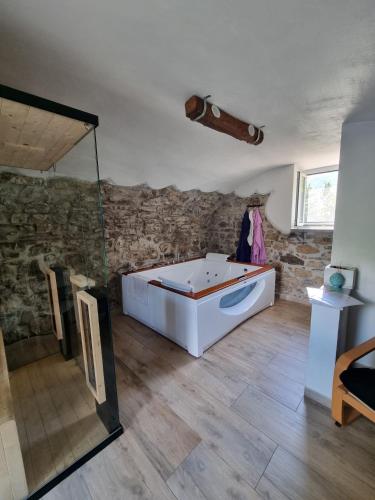 a bath tub in a room with a stone wall at "Rosa di sera" - Relax in Toscana con Spa privata in Tresana