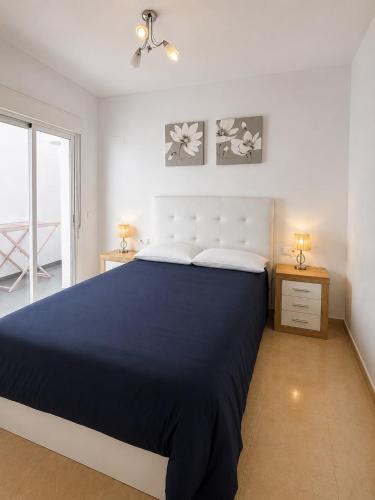 a bedroom with a large bed with a blue blanket at Skandi home in Gran Alacant