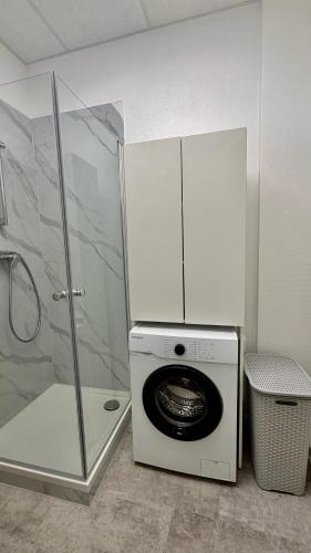 a washing machine and a shower in a bathroom at MeBa Living Business Suite Mönchengladbach in Mönchengladbach