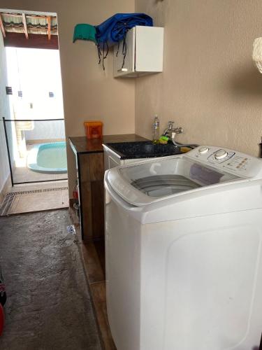a washing machine in a kitchen with a sink at Recanto Peixoto in Olímpia