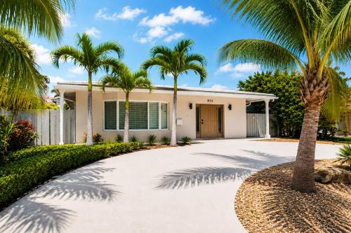a palm tree in front of a house with a driveway at Walk to Hollywood Beach Luxury 4BR Villa in Hollywood