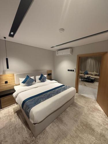 a bedroom with a large white bed with blue pillows at Bright Moon in Al-ʿUla