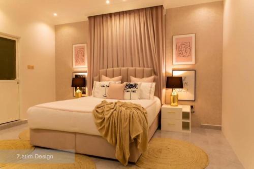 a bedroom with a large white bed and two lamps at Chalet A4 Mirbat in Mirbāţ