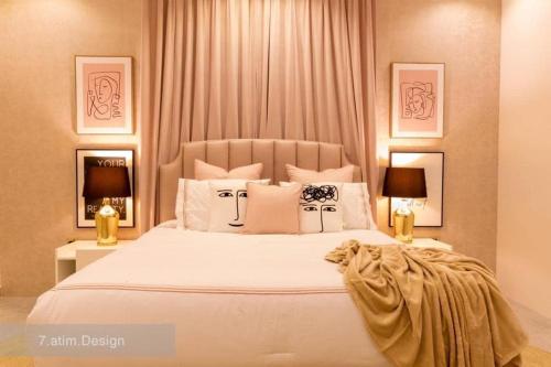 a bedroom with a large white bed with two lamps at Chalet A4 Mirbat in Mirbāţ