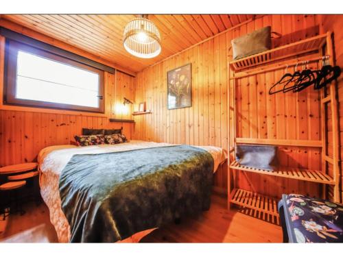 a bedroom with a large bed in a wooden room at Le Beau Renard in Heure