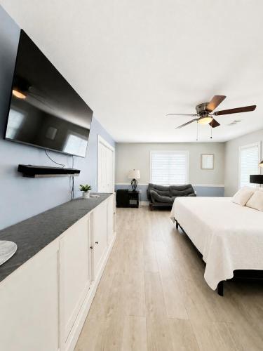 a white bedroom with a bed and a ceiling fan at Bradenton Oasis Private Backyard and Firepit in Bradenton