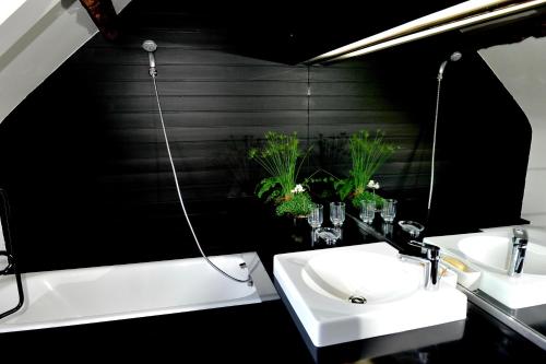 - deux lavabos dans une salle de bains aux murs noirs dans l'établissement Gite de la Ruaudais, à Bréal-sous-Montfort