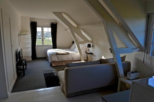 salon z łóżkiem i kanapą w pokoju w obiekcie Gite de la Ruaudais w mieście Bréal-sous-Montfort