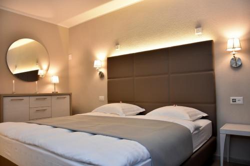 a bedroom with a large bed and a mirror at Rotonda in Gordola