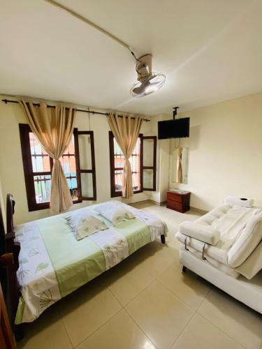 a bedroom with two beds and a flat screen tv at Hotel casa gustadora in Cali