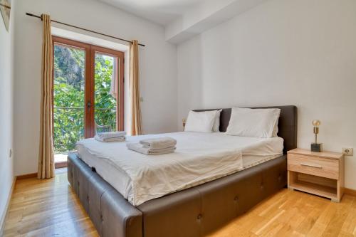a bedroom with a large bed with a window at Fiumera Kotor Apartment in Kotor