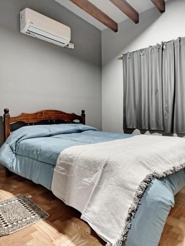 a bedroom with a bed and a air conditioner at Alojamiento Quilla-Unta in Fiambalá