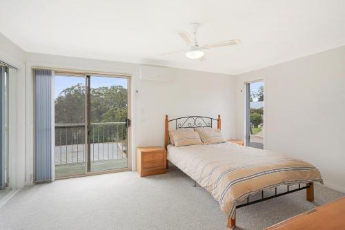 a bedroom with a bed and a large window at Holiday on Pacific in Tathra