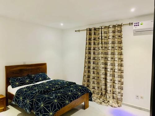 a bedroom with a bed and a curtain at Amazone in Ngaparou