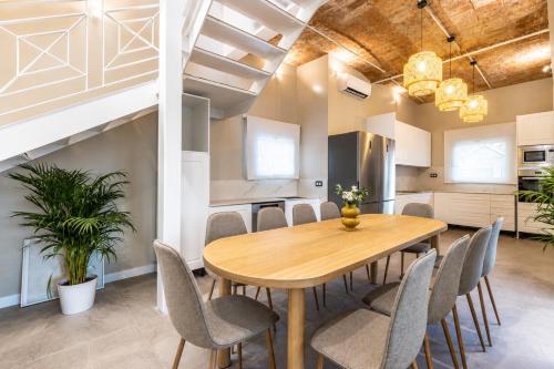 a dining room with a wooden table and chairs at Villa MORERA in Vilaseca de Solcina