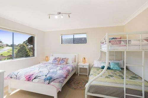 a bedroom with a bunk bed and a window at Fanta Sea in Tathra