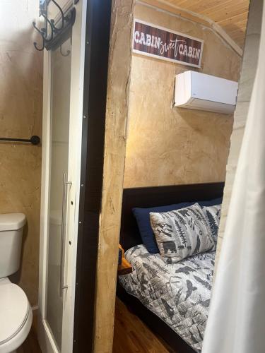 a small bed in a tiny house with a toilet at The Last Resort in Ruidoso