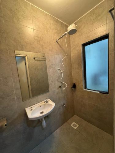 a bathroom with a sink and a mirror and a window at KHomes Luxury Bed & Breakfast in Nairobi