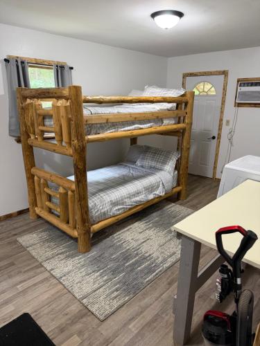 a room with two bunk beds and a desk at Maple Ridge Trail Side Cabin in Crandon