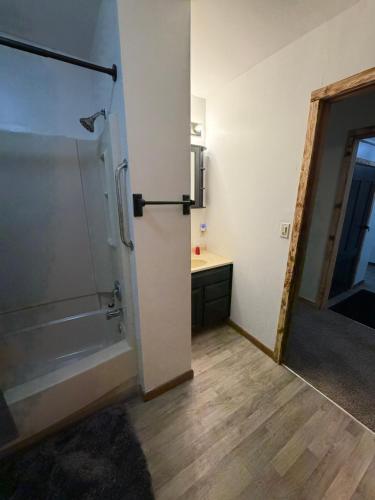 a bathroom with a shower and a tub and a sink at Maple Ridge Trail Side Cabin in Crandon