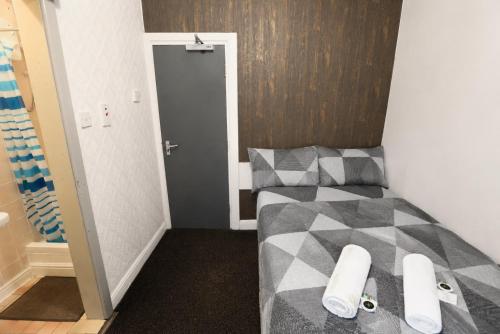 a small room with a bed and a door at Blackpool Central Lodge in Blackpool