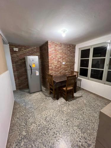 a dining room with a table and a refrigerator at Alojamiento LowCost San Rafael in San Rafael