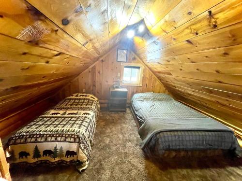 a bedroom with two beds in a log cabin at Caribou Cabin -Rustic Cabin with Sauna in Delta Junction