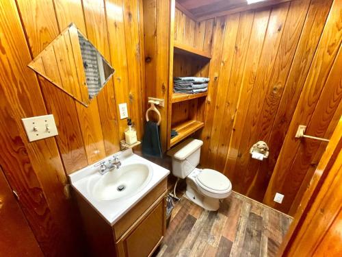 a wooden bathroom with a sink and a toilet at Caribou Cabin -Rustic Cabin with Sauna in Delta Junction