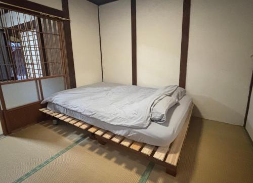 a bed in a room with a wooden frame at Aoi-Yane Traditional Japanese House in Kumano Kodo Nakahechi in Tanabe
