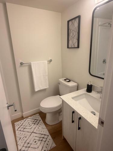 a white bathroom with a toilet and a sink at Urban Nest in Edmonton