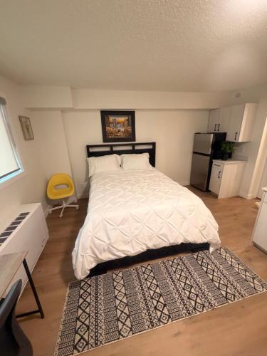 a bedroom with a bed with a white comforter at Urban Nest in Edmonton