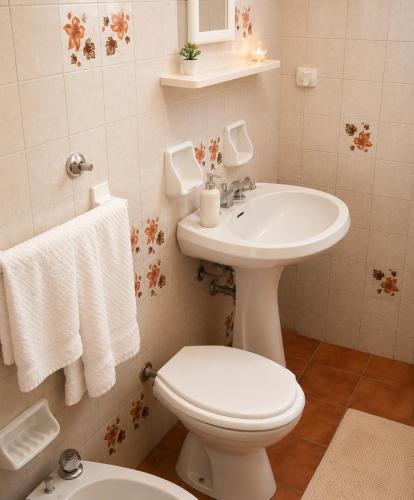 a bathroom with a white toilet and a sink at Villa Olimpo B&B in Fasano